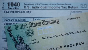 Form 1040 U.S. Individual Income tax return next to the Stimulus Check Relief program. Close up view.