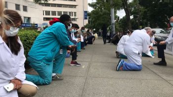 Health care workers take a knee outside Seattle hospital to support protests