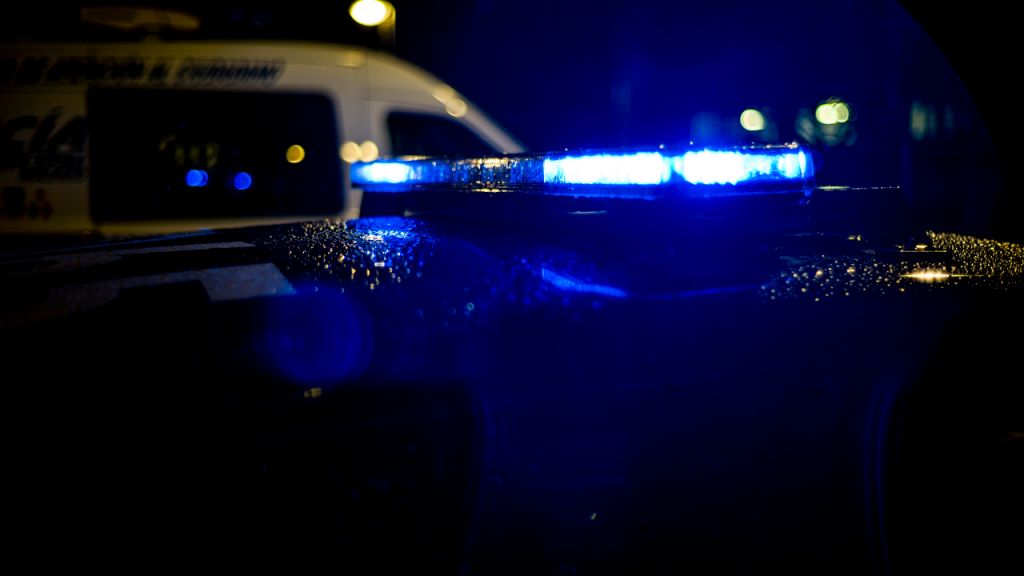 Spain, Madrid, rain falling on a police car at night