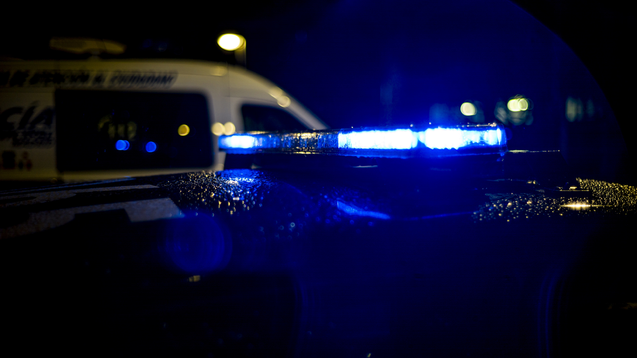 Spain, Madrid, rain falling on a police car at night